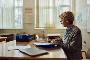 Female teacher writing her plans in the classroom.