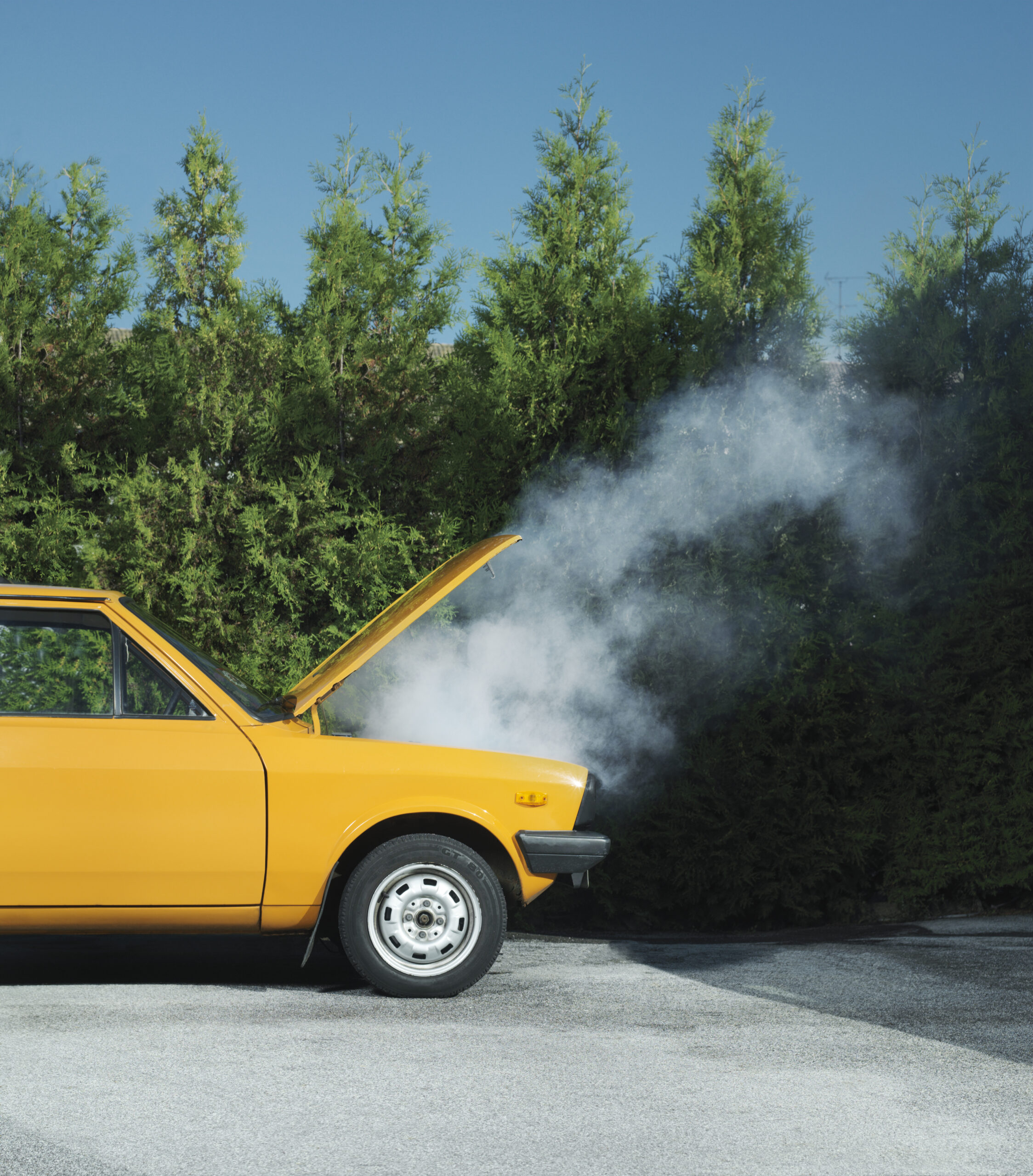 Yellow car with steam pouring from bonnet